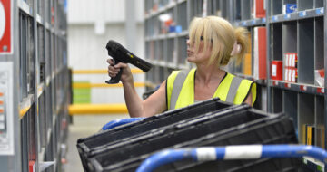 Woman scanning shelves in warehouse