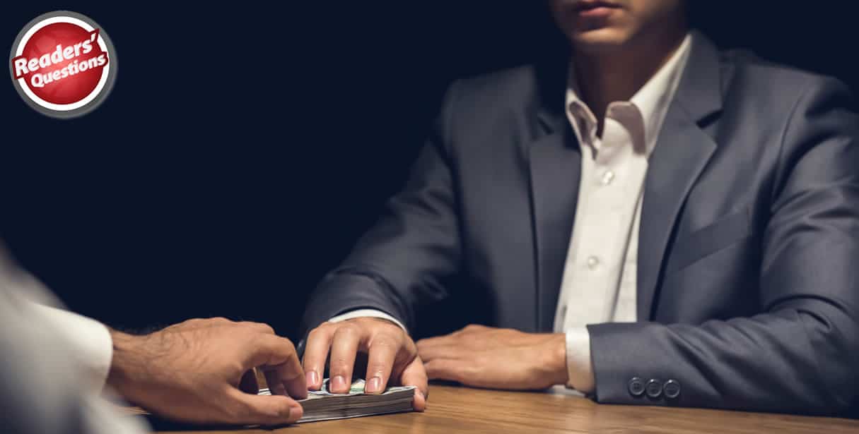 Man taking bribe across table