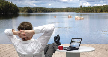 Man with PC relaxing by lake