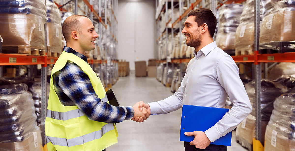 Men shaking hands in warehouse