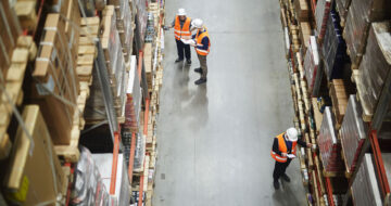 Workers managing inventory in warehouse