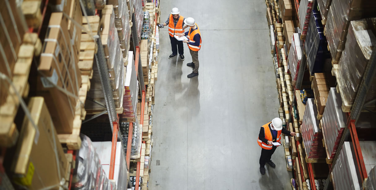 Workers managing inventory in warehouse