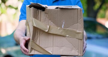 Delivery man handing over damaged parcel