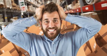 Man stressed in warehouse with parcels