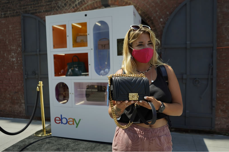 Woman with handbag next to eBay vending machine