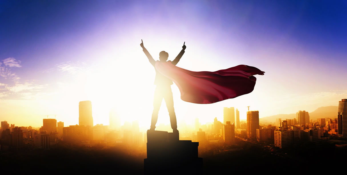Man with cape celebrating above skyline